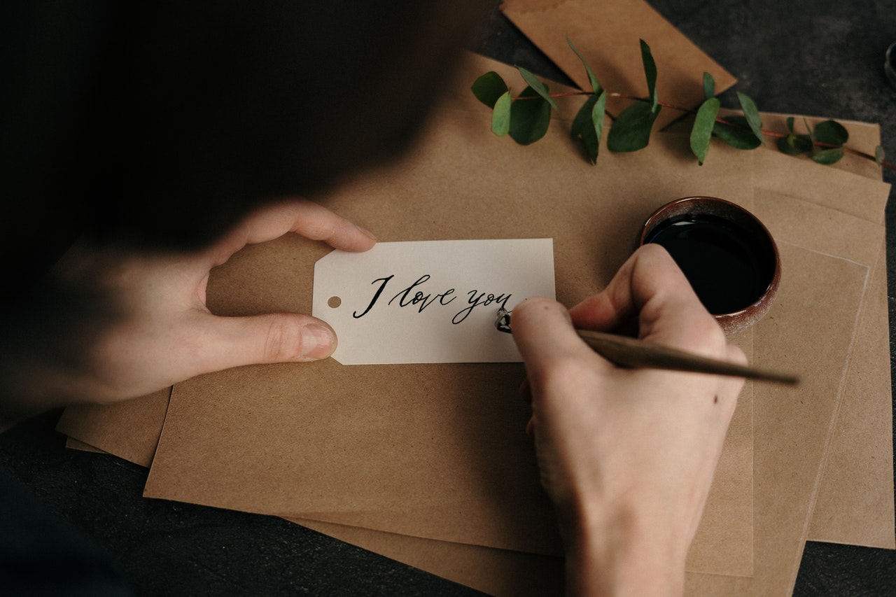 Mężczyzna pisze na kartce wyznanie miłości
