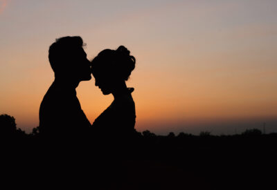 Chłopak i dziewczyna na tle zachodzącego słońca i teksty na podryw rzucane przez chłopaa