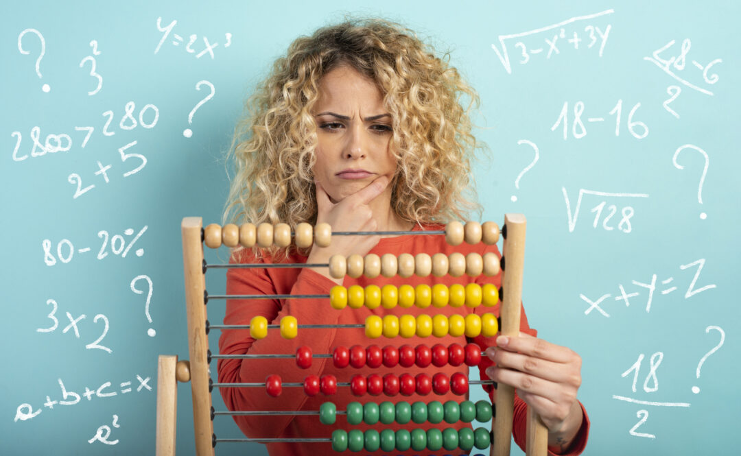 Dorosła kobieta rozwiązuje zagadnienia matematyczne